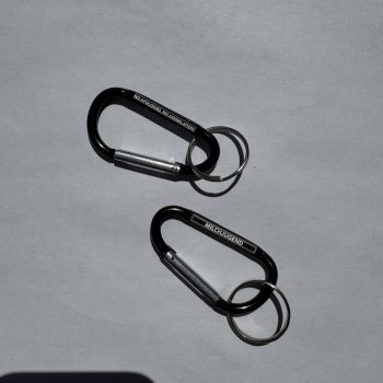 Karabiner Gravur «No apologies. No assimiliation.» auf Vorderseite und Gravur «Milchjugend» auf Rückseite